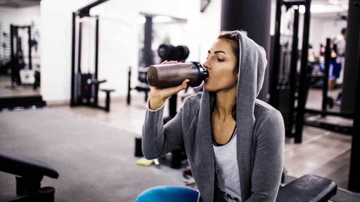 woman-in-gym-drinking-protein-shake-1296x728